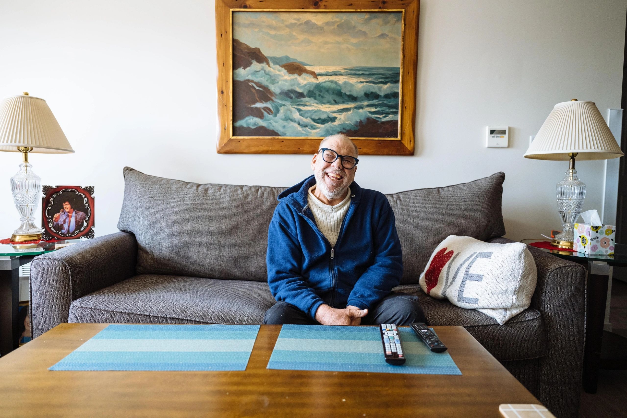 Young man sitting on a sofa indoors smiling